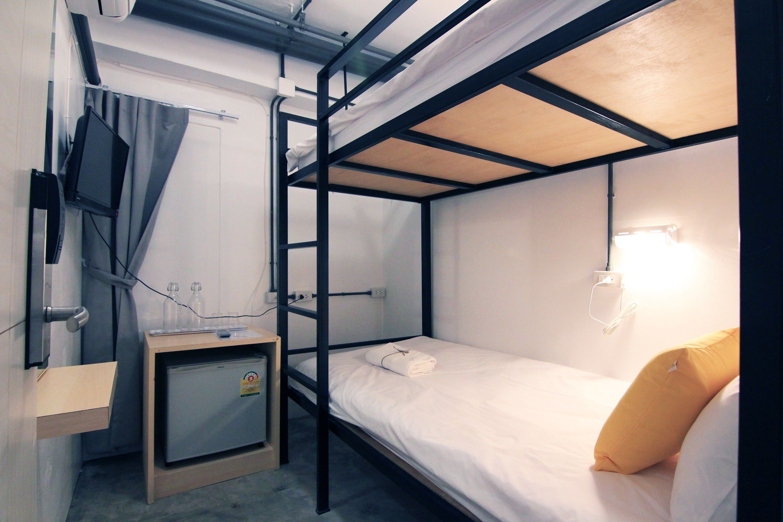 A bunk bed with a small desk and a television.
