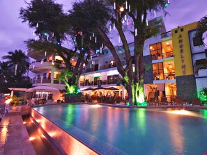 Alberca al aire libre, sombrillas en la alberca y camastros 