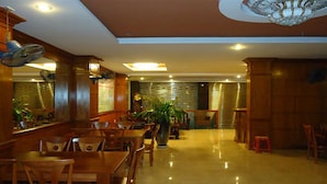A restaurant with wooden furniture, ceiling fans, and a chandelier. - Phu An Hotel (Ho Chi Minh City)