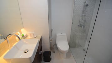 A bathroom with a sink, toilet, and glass-enclosed shower.
