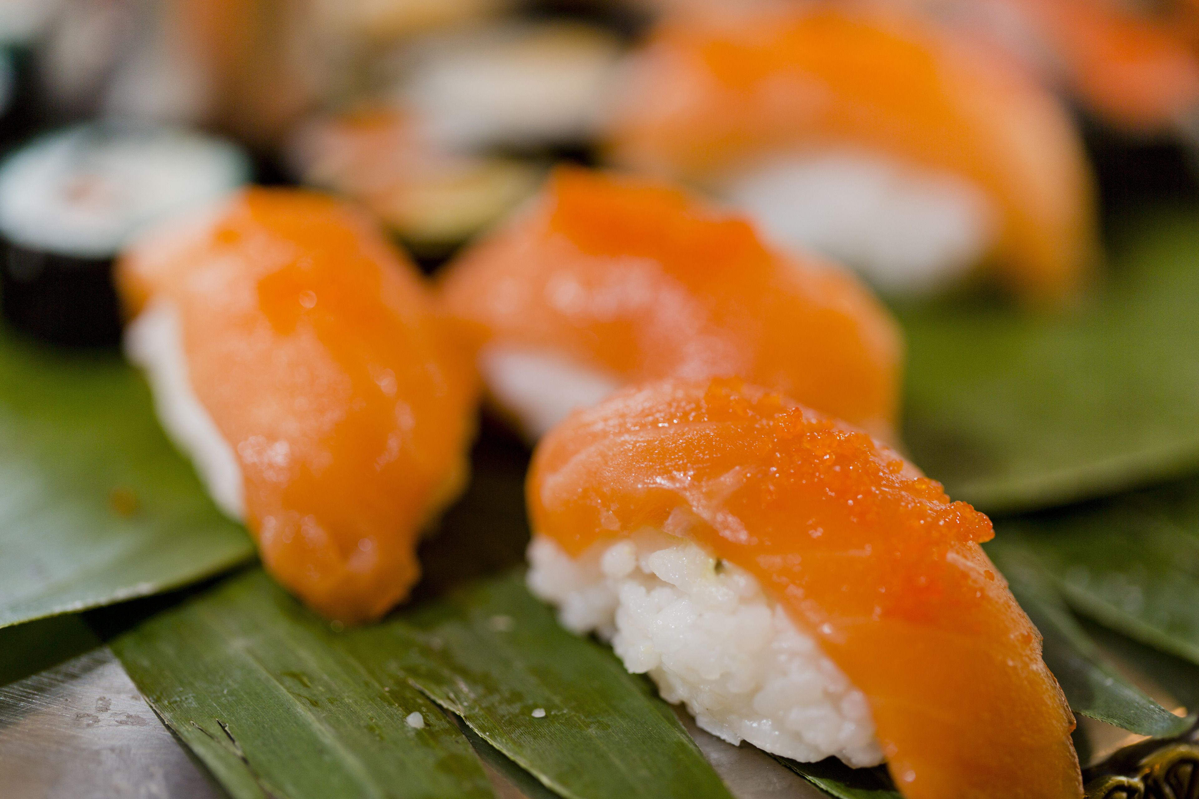Sushi rolls with salmon on a leaf.