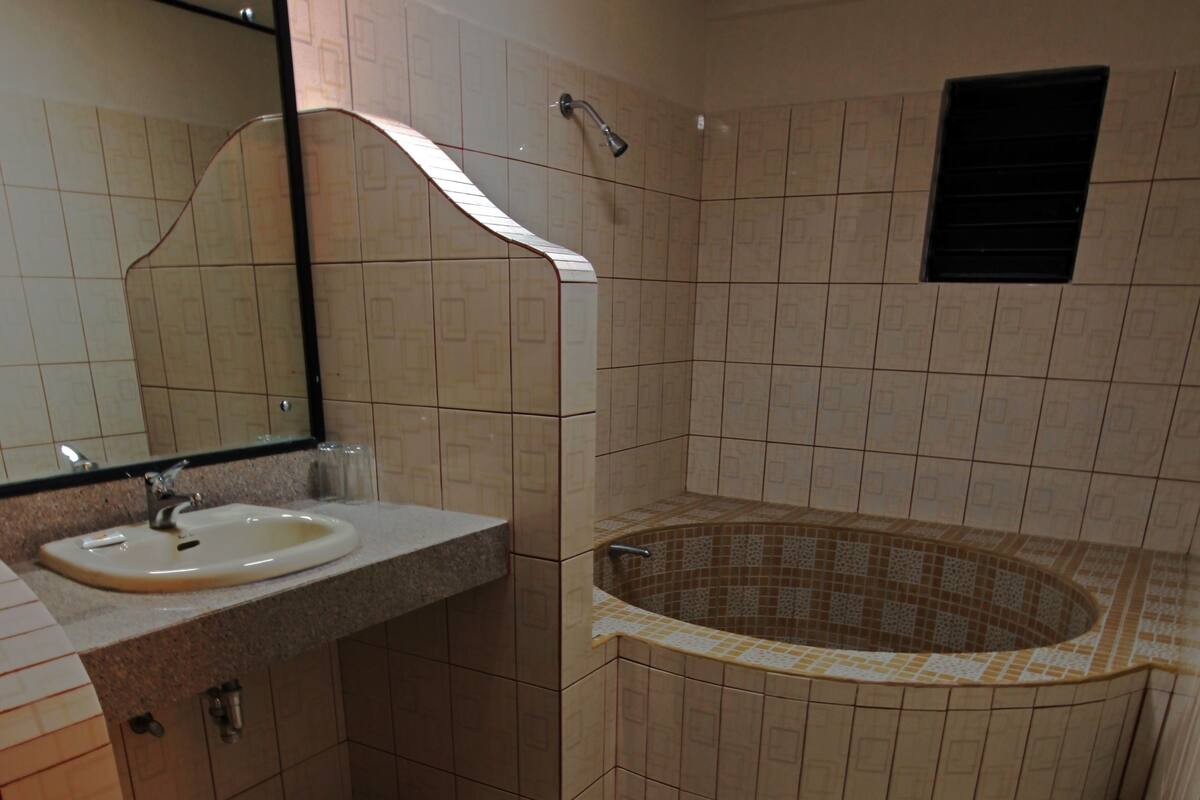 A bathroom with a sink, mirror, and a freestanding bathtub.