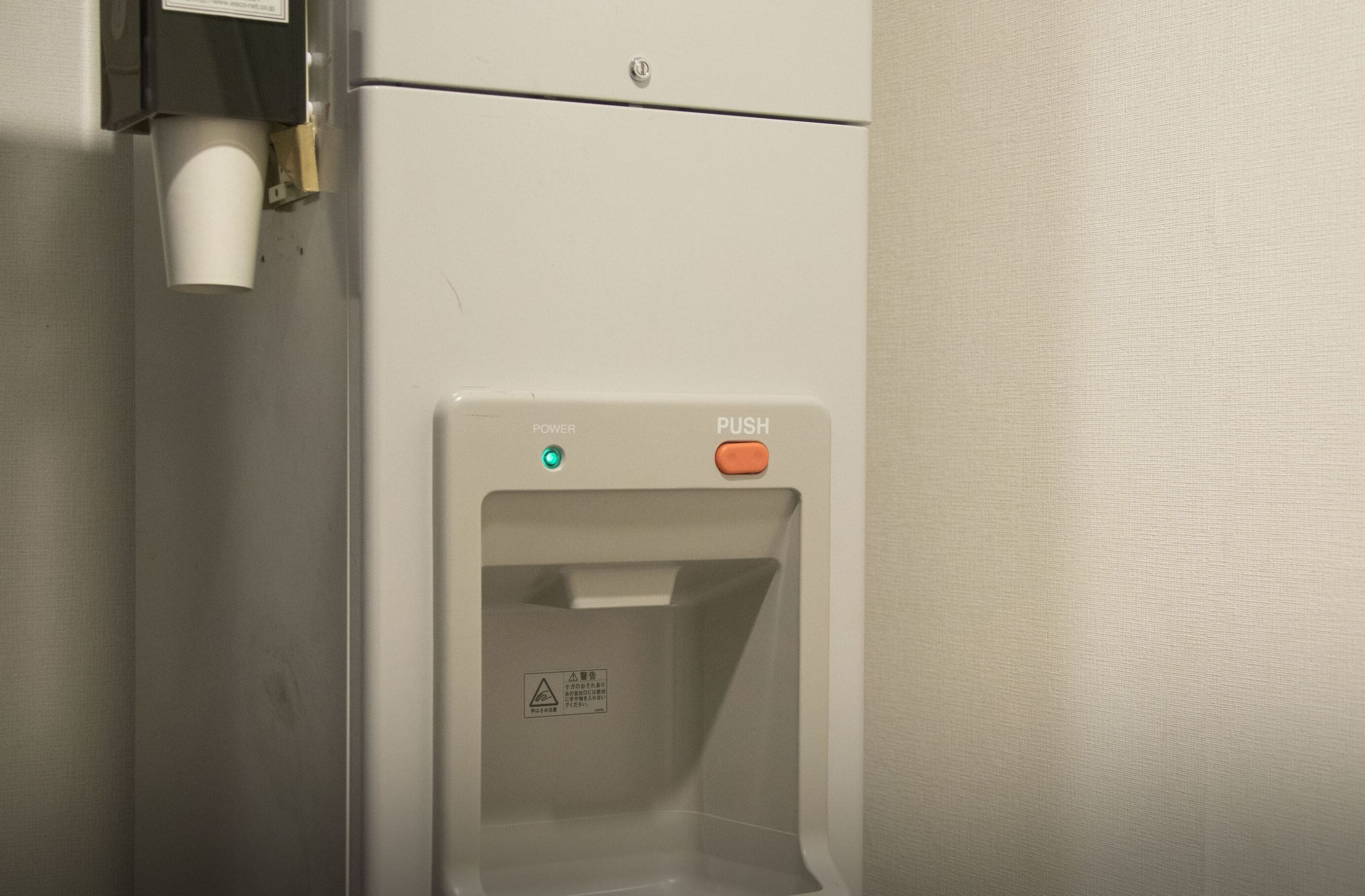 A restroom with a paper towel dispenser and a hand dryer.