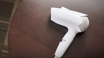 A white hair dryer on a round table.