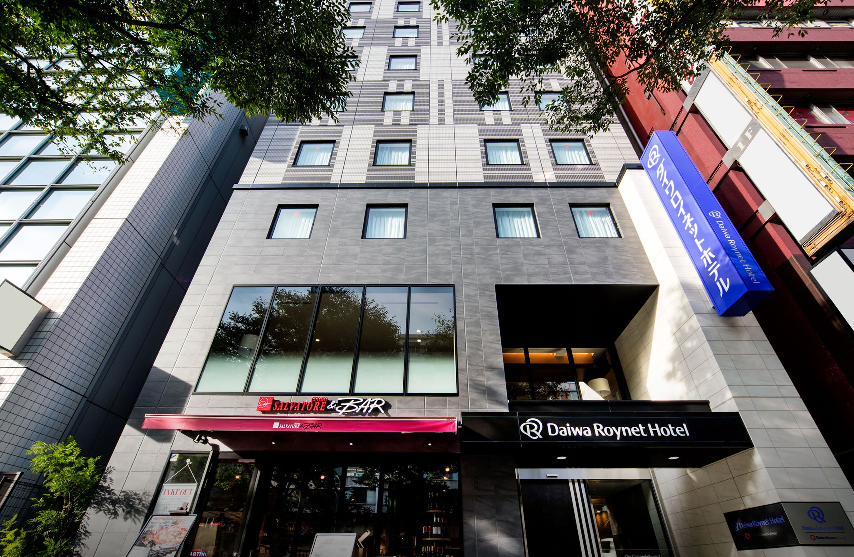 Un edificio moderno con un bar chiamato "Millerati Bar" e un hotel chiamato "Daiwa Roynet Hotel".