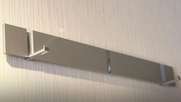 A wall-mounted, metallic, rectangular shelf with a minimalist design, likely used for storage or display purposes.