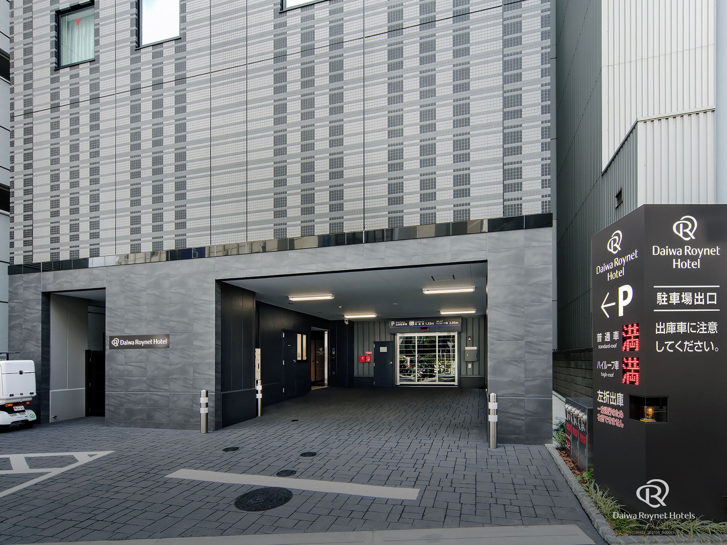 The Daiwa Roynet Hotel entrance with a parking sign, a covered walkway, and a modern building facade.