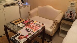 A hotel room with a bed, a small desk with a computer, a chair, and a table with magazines and a remote control. - Hotel HUG-HUG KYOTO - Adults only (Kyoto)