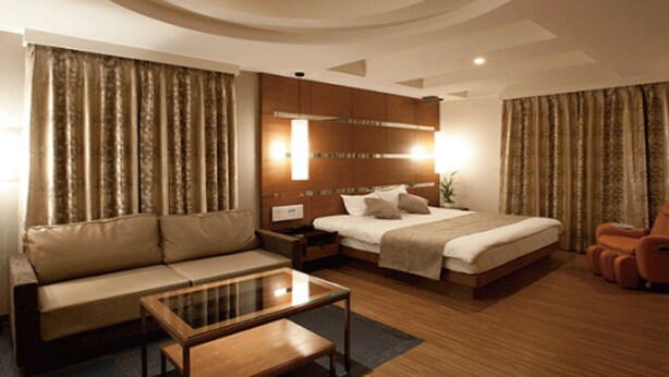 A modern hotel room with a large bed, a sofa, a glass-top coffee table, and a wooden floor. - Hotel HUG-HUG KYOTO - Adults only (Kyoto)