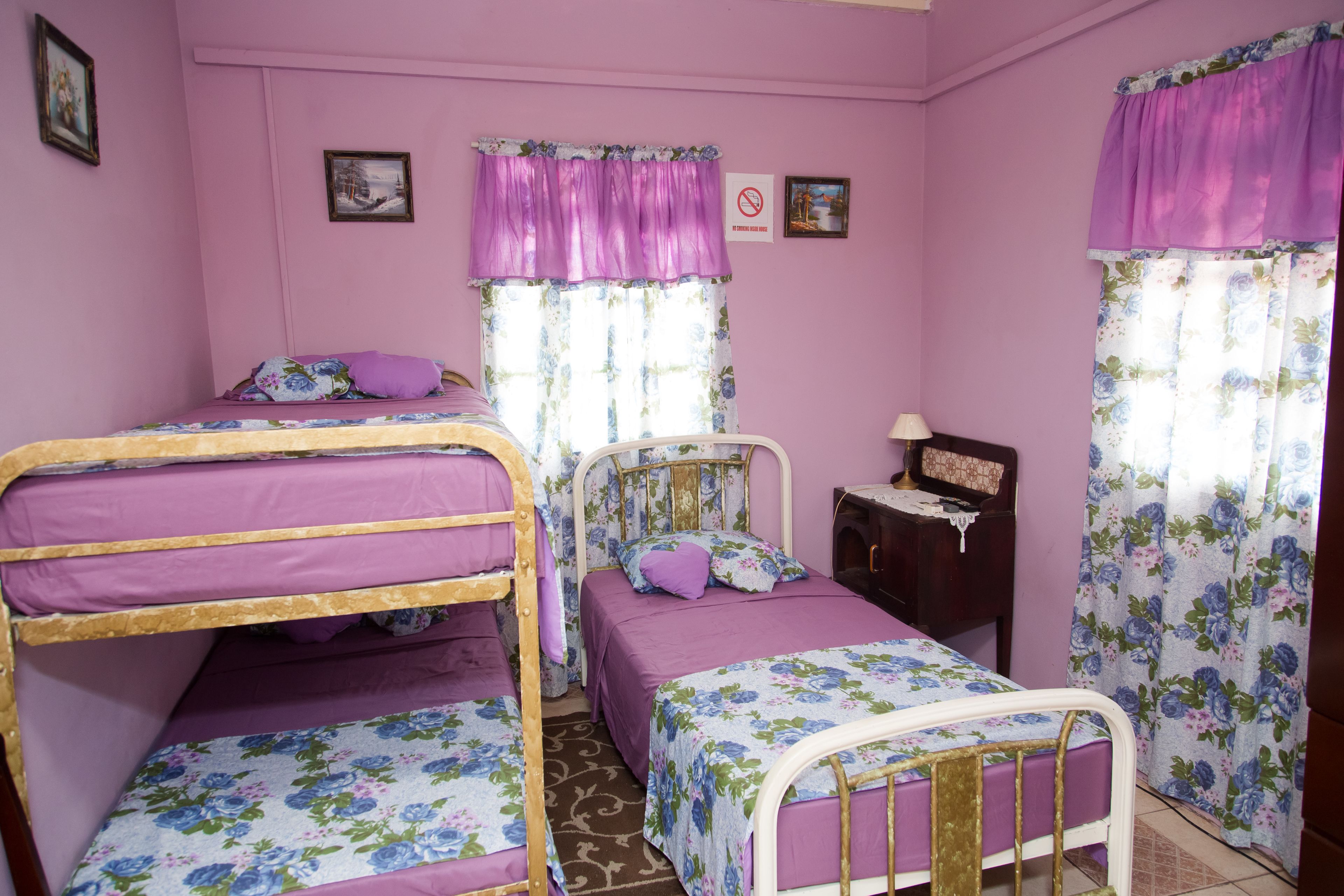 A room with two bunk beds, a single bed, a small desk, and a chair.