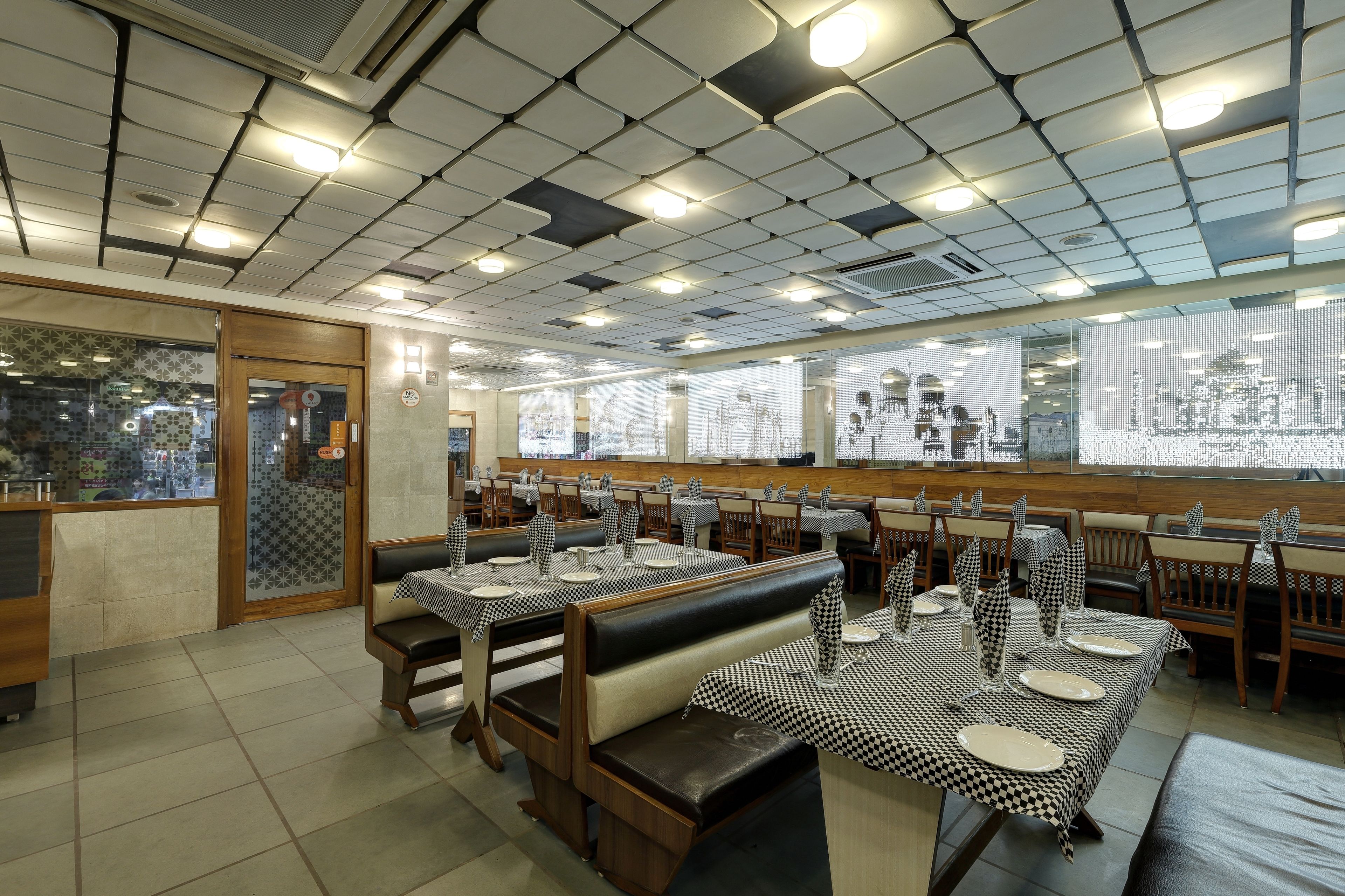 Un restaurante con manteles a cuadros, cabinas de madera y techo de baldosas.