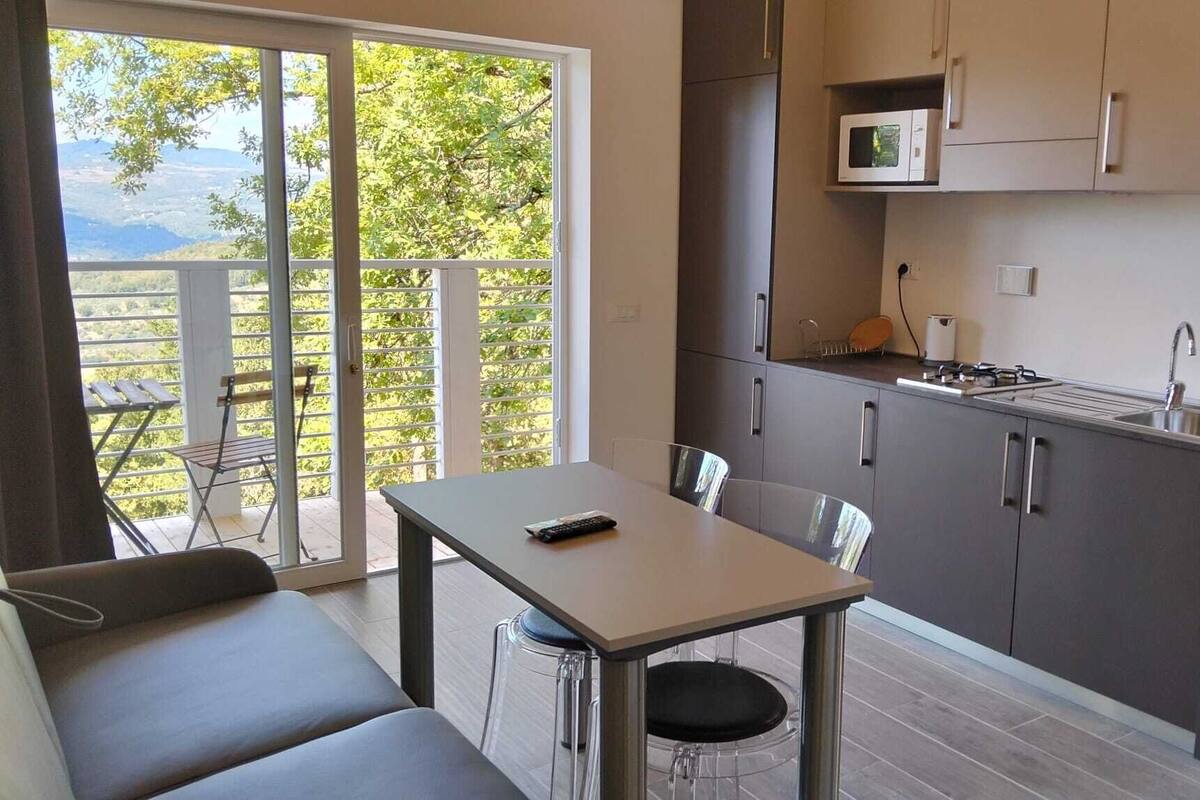 Een compacte keuken met een eethoek, een kleine tafel en uitzicht op de omgeving.