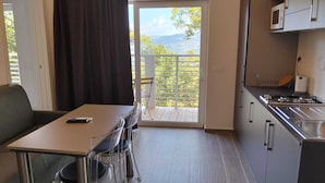 Una cocina compacta con comedor, vistas al exterior y una pequeña mesa con una silla.