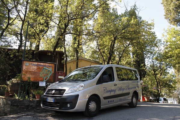 Una furgoneta plateada estacionada frente a un cartel de Camping Panorama Verde.
