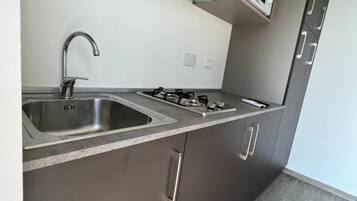 A modern kitchen with stainless steel appliances, a built-in microwave, and grey cabinetry.
