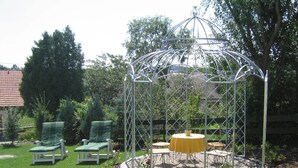 A gazebo with a yellow table and chairs in a garden. - Wirth z Moosham (Kirchdorf)