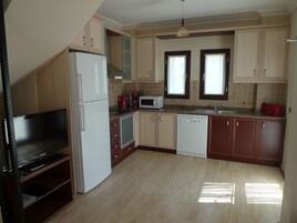 A kitchen with a refrigerator, microwave, coffee maker, and dishwasher.