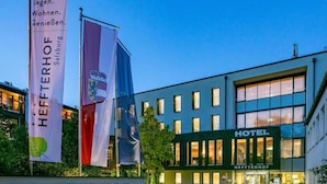 Ein Hotelgebäude mit einem Schild, auf dem ‘HEFFTERHOF’ steht, und Flaggen.