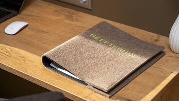 A wooden desk with a laptop, a mouse, and a brown folder labeled "HEFFTENDORPH".