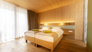 Ein Schlafzimmer mit Holzwänden, einem großen Bett, einem Nachttisch und einem Beistelltisch.