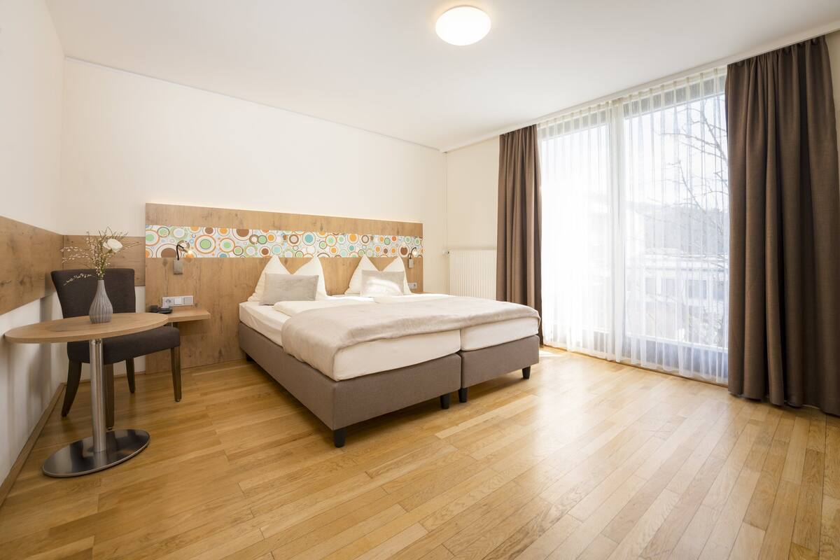 Een moderne hotelkamer met een bed, een tafeltje en een stoel.