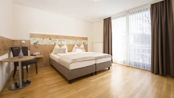 Ein modernes Hotelzimmer mit einem Bett, einem kleinen Tisch und einem Stuhl.