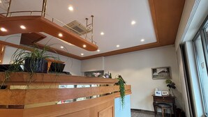 A reception desk with a wooden finish, a ceiling with recessed lighting, and a marble floor. - Hotel Krone Neuenburg (Neuenburg am Rhein)