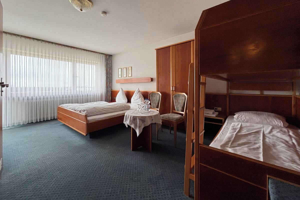 Ein Hotelzimmer mit einem Bett, einem Schreibtisch mit Stuhl und einem Kleiderschrank.