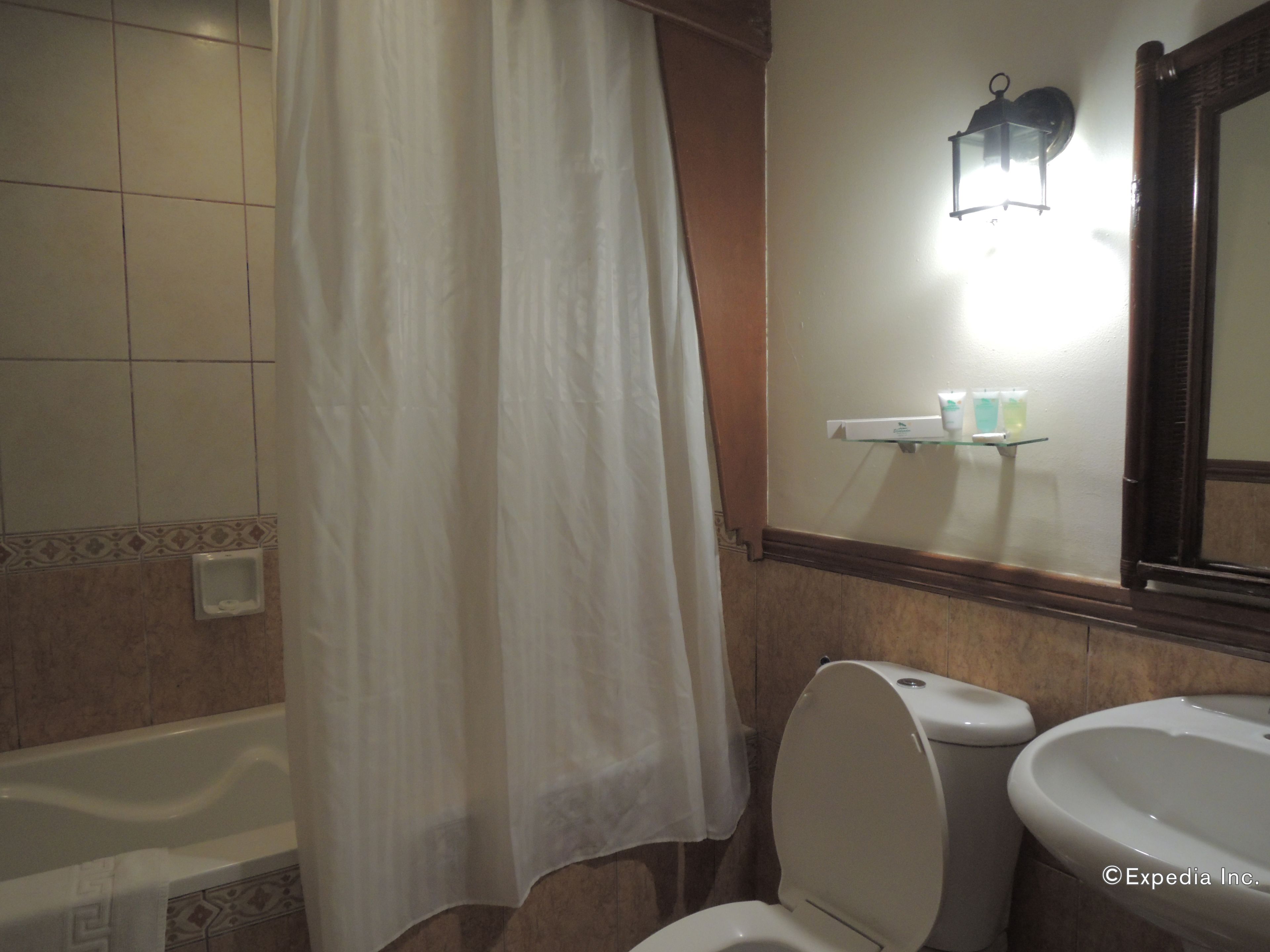 A bathroom with a bathtub, toilet, and sink.
