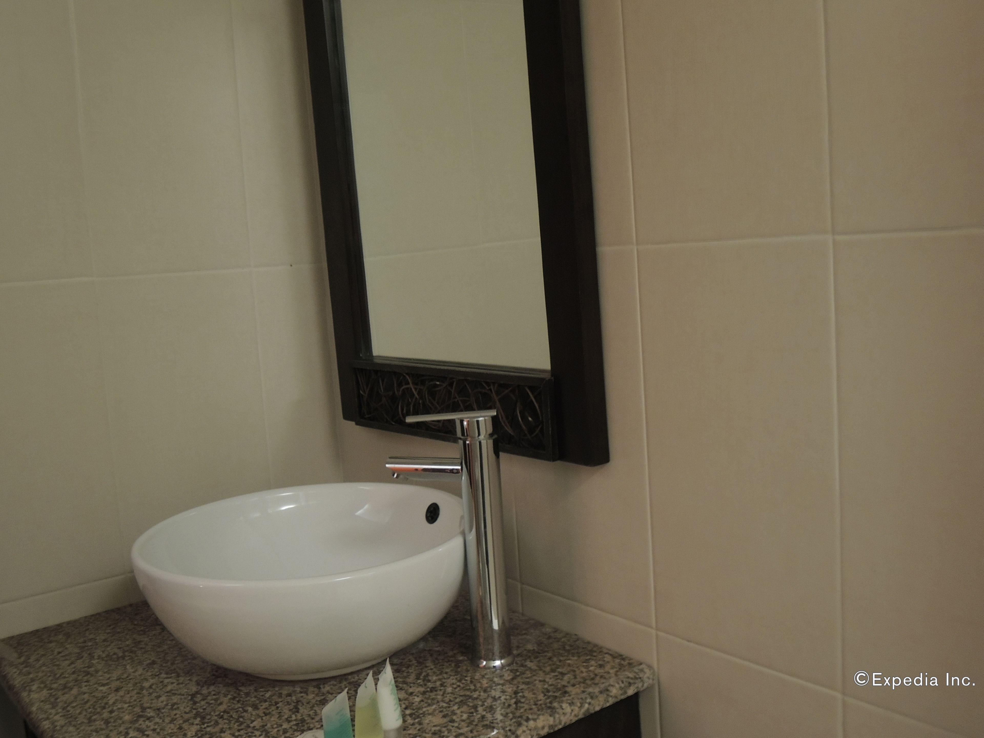 A bathroom with a white sink, a mirror, and a granite countertop.