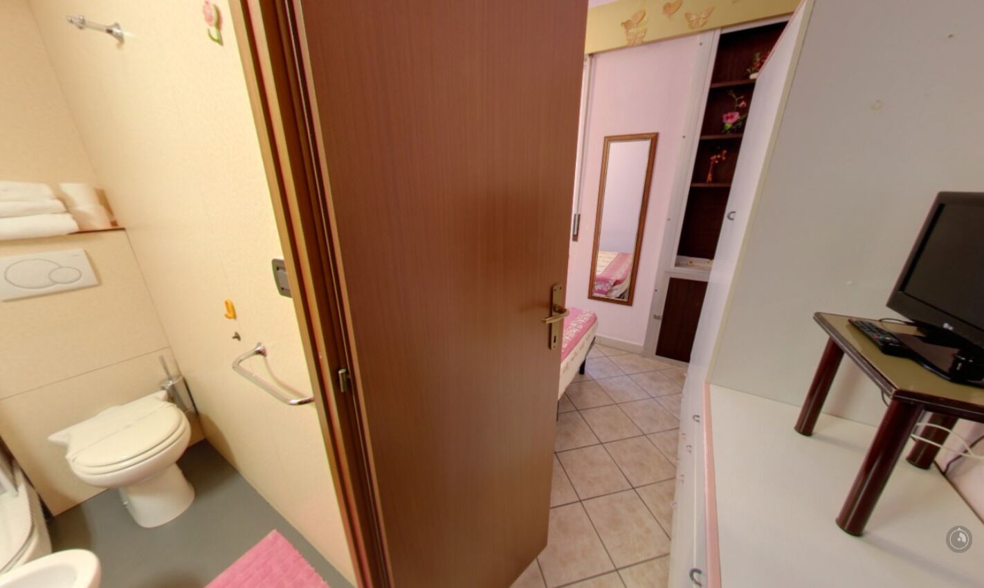 Un bagno con un water, un bidet e delle maniglie di sostegno.