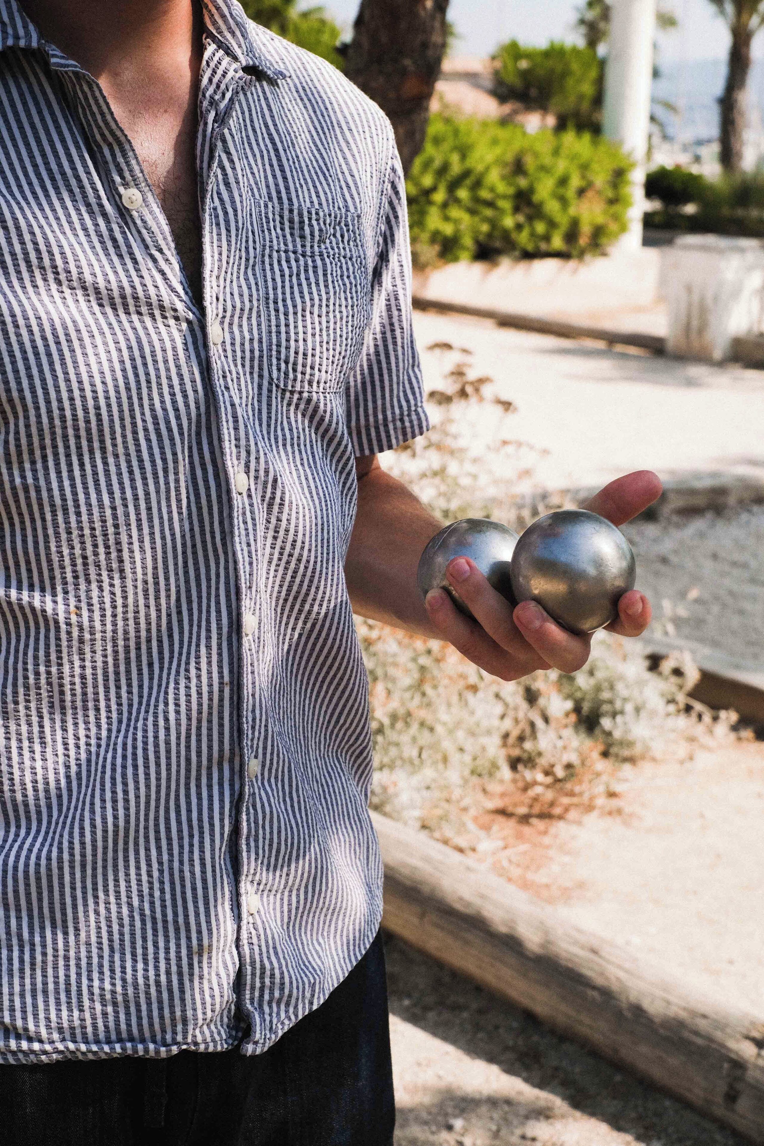 A person holding two metallic balls.