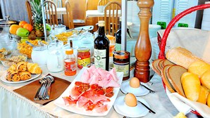 Un bufé de desayuno con diversos alimentos, como frutas, pasteles y salsas.