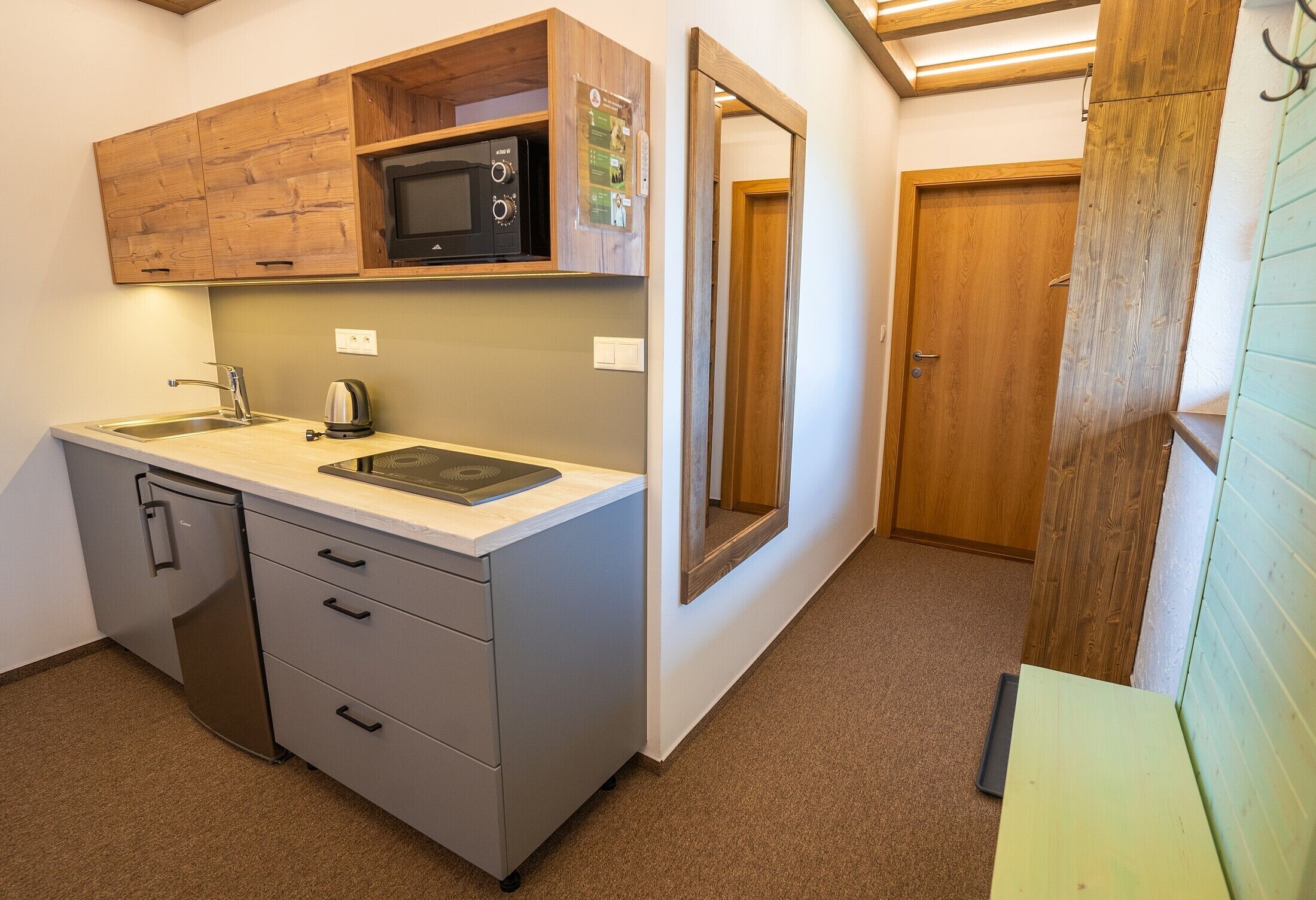 A compact kitchen with a built-in microwave, a sink, and a dishwasher.