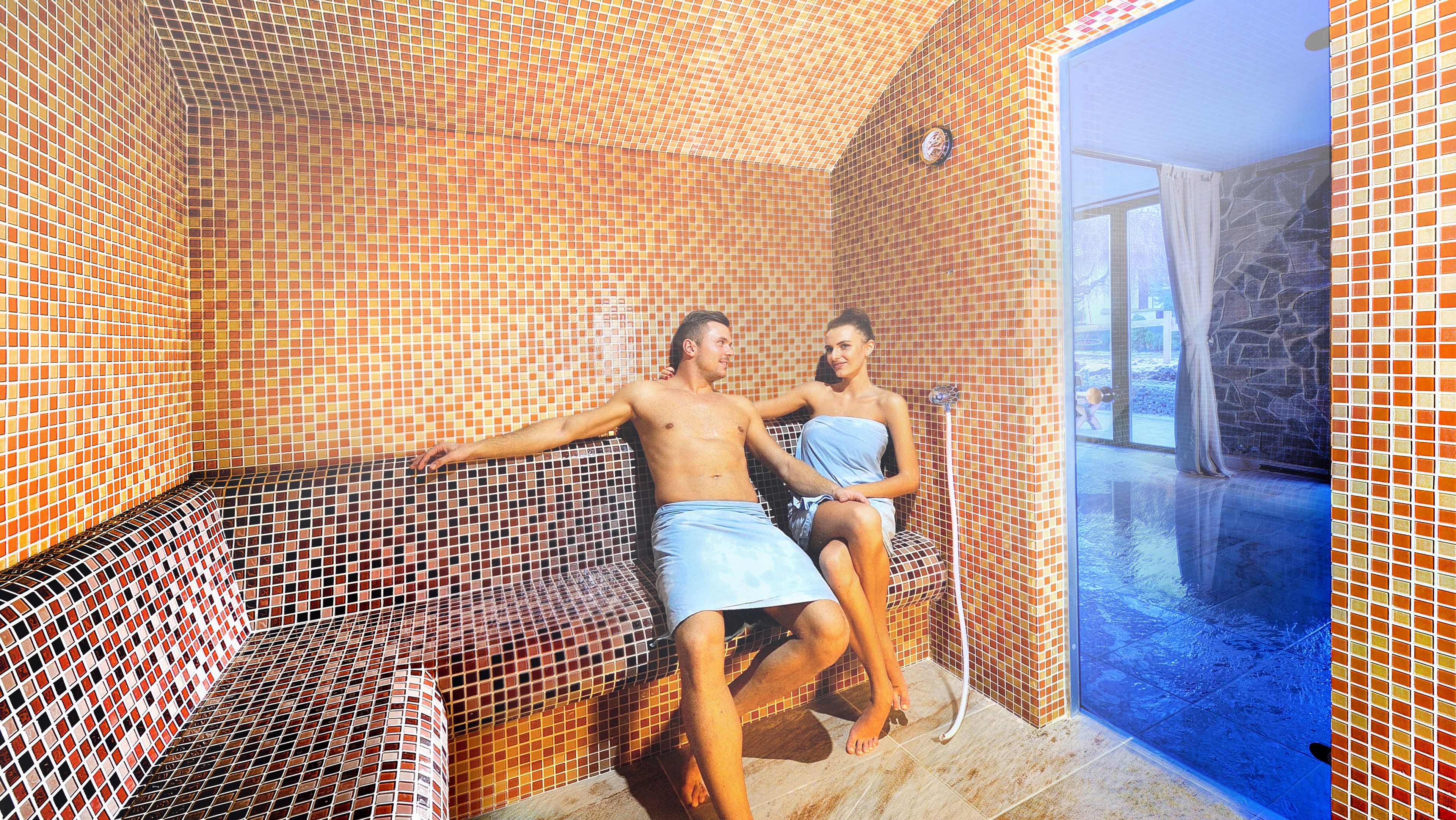 Una habitación con pared de azulejos y un banco.