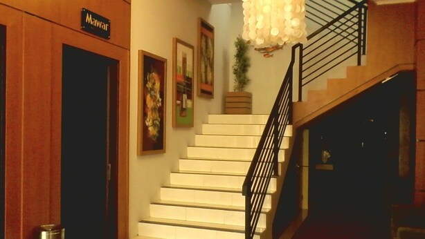 A staircase with a black railing, a wooden door labeled "Mawart," and a hanging light fixture. - Sarila Hotel Sukoharjo (Sukoharjo)