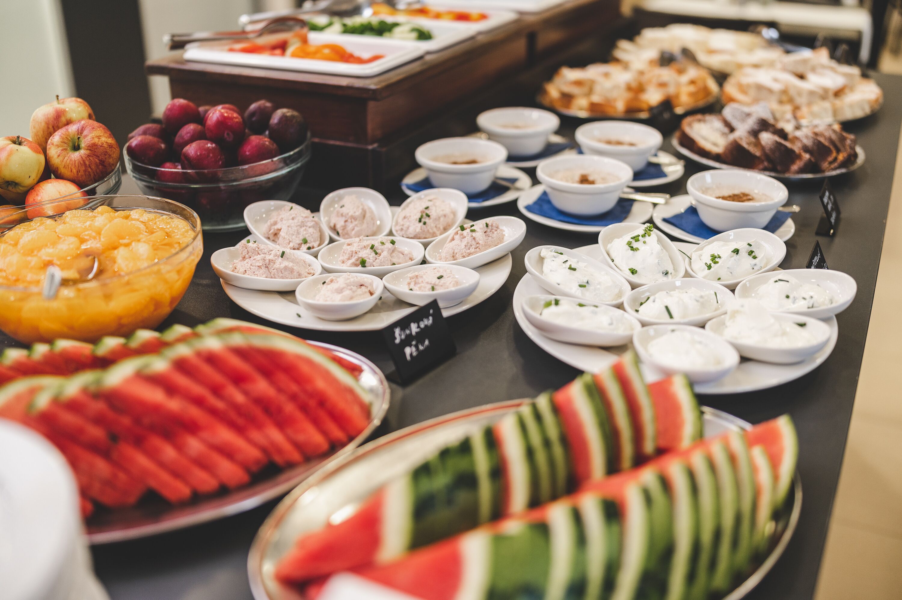 Ein Buffet mit verschiedenen Speisen, darunter Obst, Salate und Desserts.