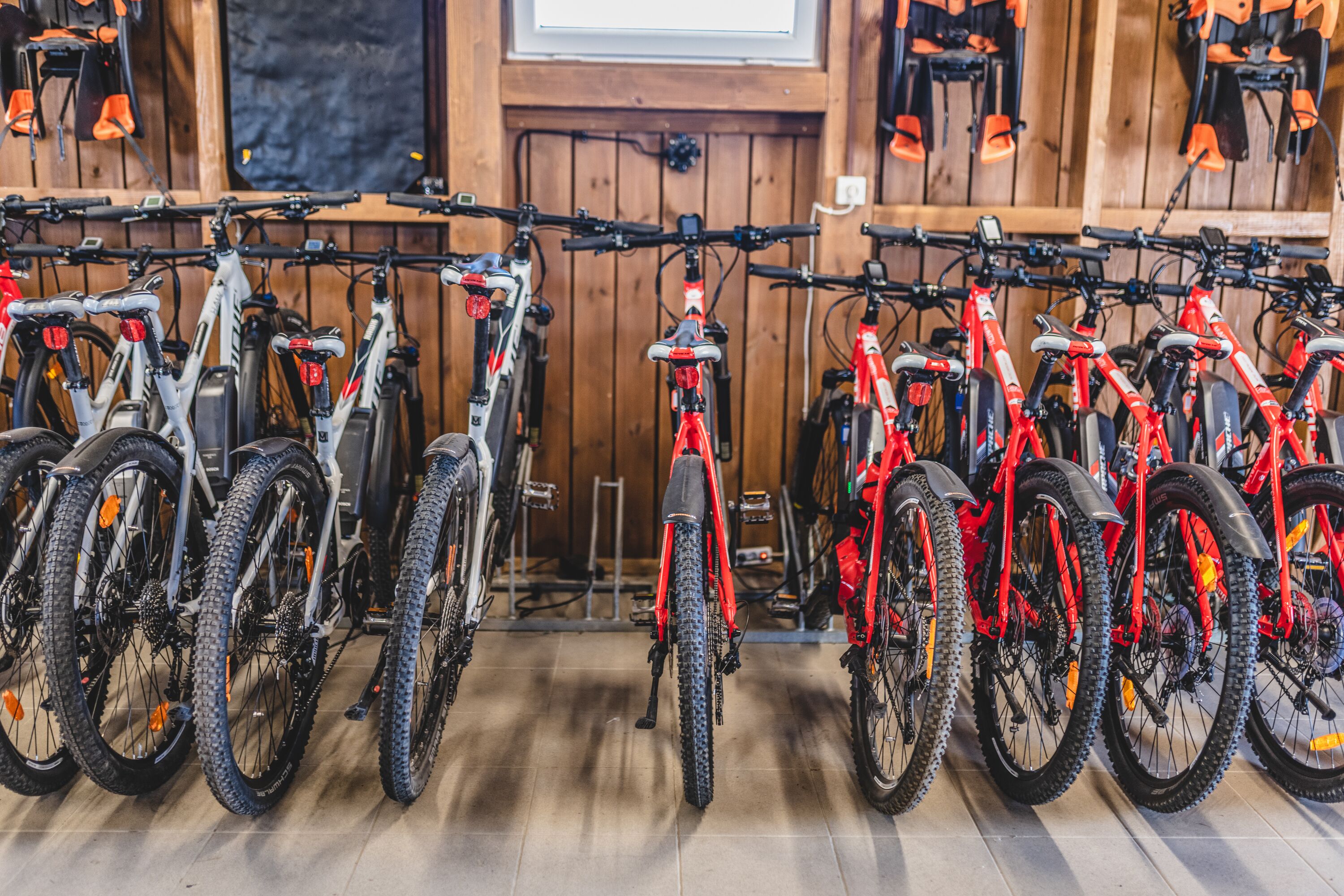 Bicycles parked in a wooden room with a wooden floor.