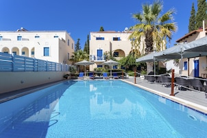 Una piscina al aire libre de temporada, sombrillas