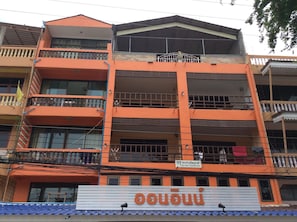 Un edificio de varios pisos con balcones y un cartel que indica que es una casa de huéspedes.