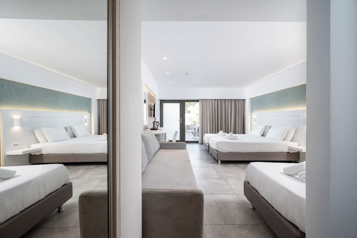 Una habitación de hotel moderna con dos camas, un sofá y una zona de comedor.