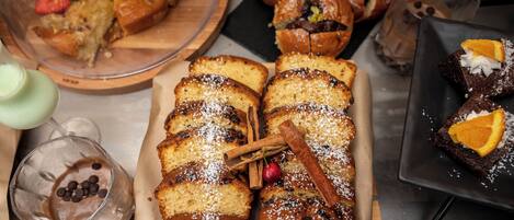 Variedad de productos de panadería, como pan y pasteles, sobre una mesa.