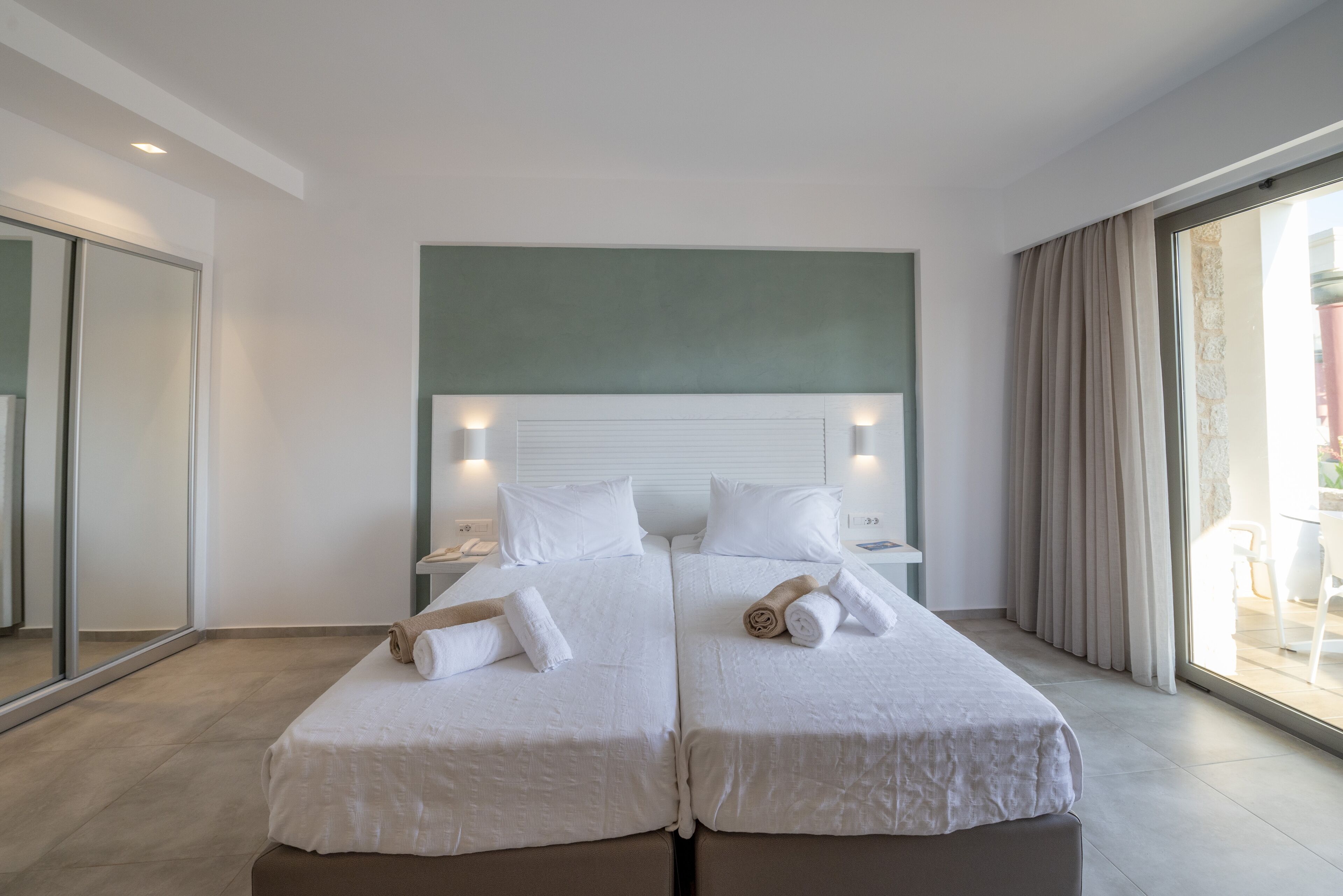 Habitación doble con dos camas, un espejo grande y vistas al exterior.