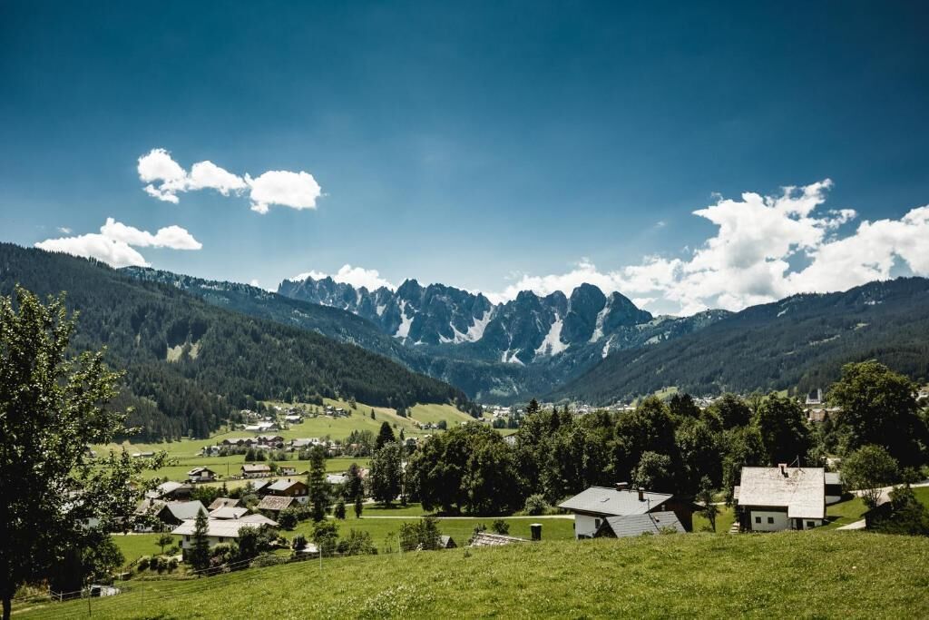 A rural village with houses and a mountain backdrop.