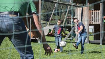 Ein Spielplatz mit einer Holzschaukel und einem umzäunten Bereich.
