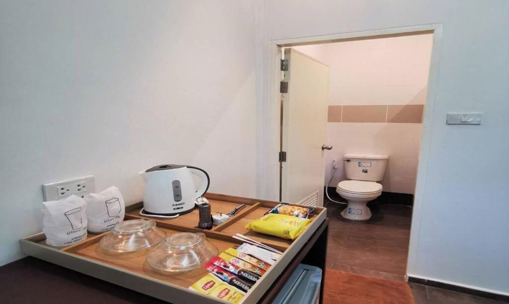 Un baño de hotel con inodoro, lavabo y una bandeja con artículos de aseo.