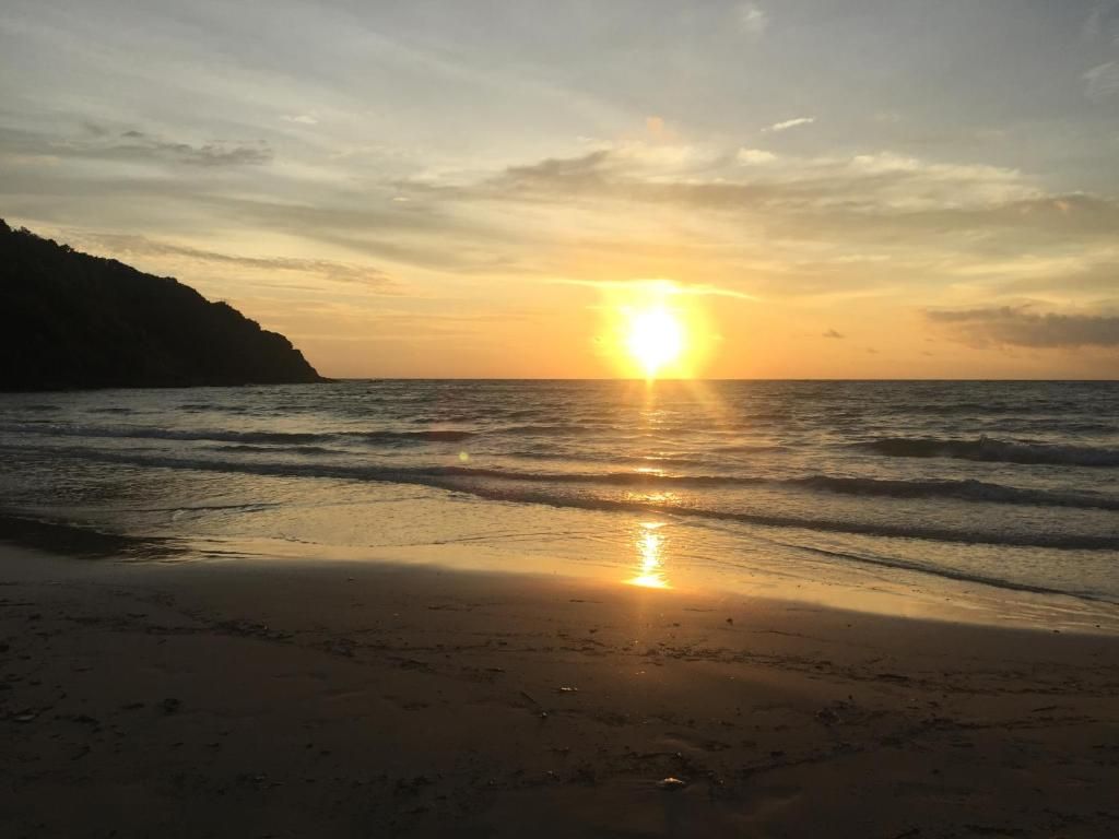 A beach with a sunset over the water.