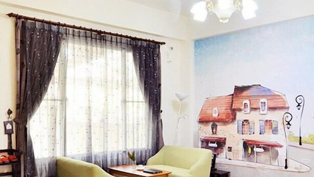 A room with a large window, a green armchair, a small table, and a shoe rack. - Buongiorno B&B-Peng's family (Taitung)