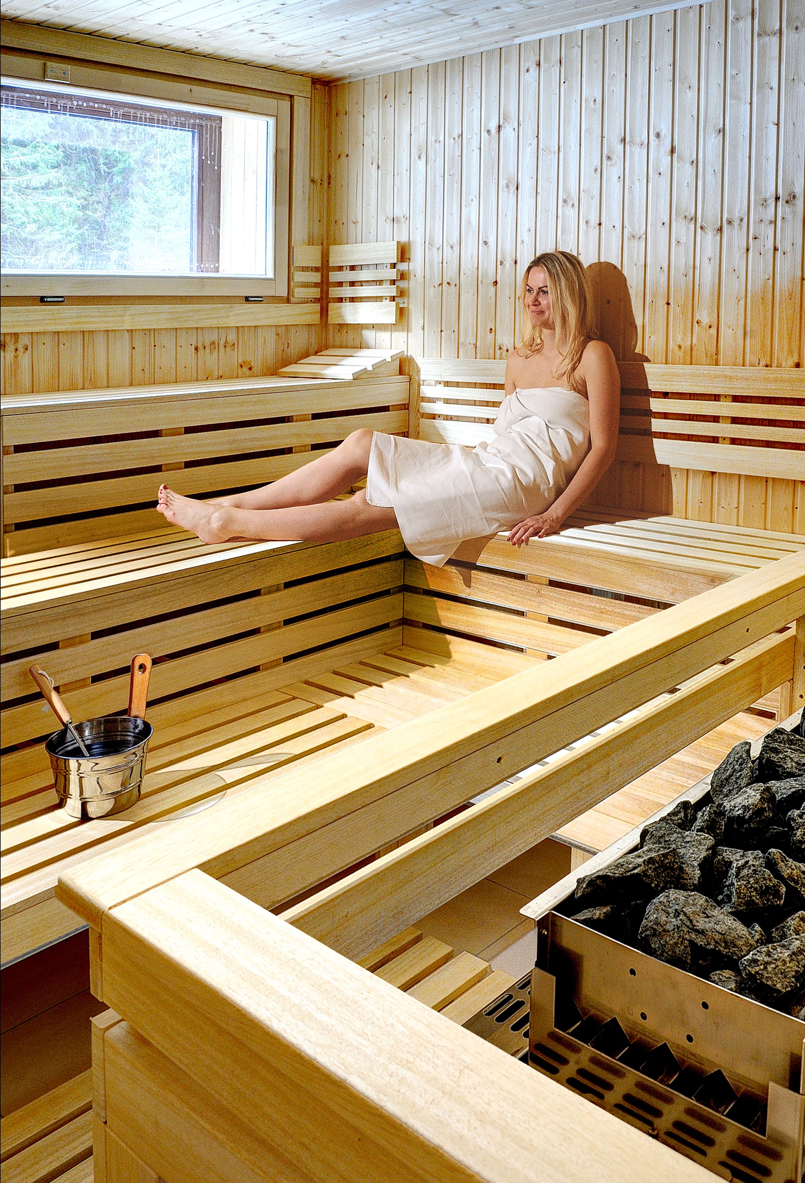 Una sauna con bancos de madera y una ventana.