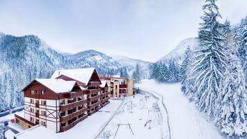 A multi-story lodge with a traditional Alpine architectural style, featuring a symmetrical facade and a central entrance.